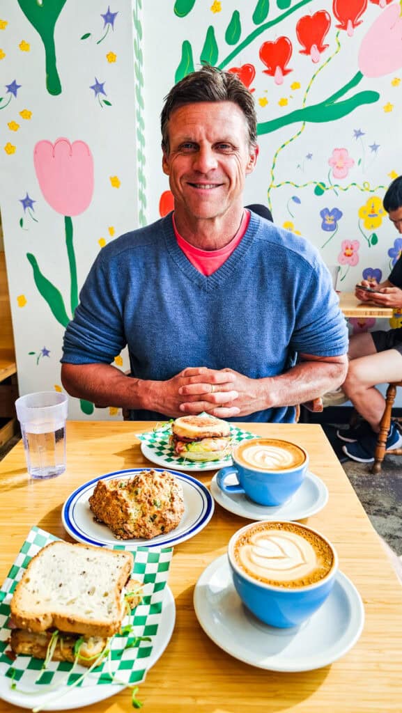 man at good luck cafe Dartmouth with coffee and breakfast sandwich